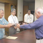 国保運営協の松川会長（左）から下地市長に国保税率を引き下げる条例の一部改正案が答申された＝11日、市長室
