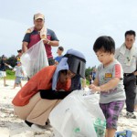 ４００人が参加し、空き缶やペットボトルなどのごみを拾い集めた＝22日、トゥリバー海岸