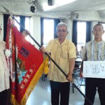 総合優勝した大木区の役員に賞状と優勝旗が下地村長（左）から授与された＝25日、多良間村中央公民館