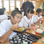 弁当をおいしそうに食べる生徒たち＝21日、上野中学校