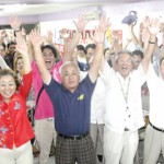 島尻さんの「当確」を受け万歳三唱を行う下地市長（左から2人目）ら支持者