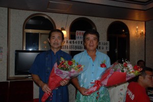 花束贈呈で祝福を受けた砂川さん（右）と真壁さん＝25日、市内の飲食店