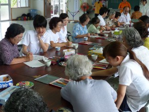 学生とお年寄りが一緒に塗り絵を楽しむ＝９日、荷川取公民館の「生きいき教室」