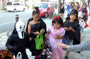 かわいい衣装やちょっと怖い衣装に身を包んだ子どもたちがお菓子を求めて通りを練り歩いた＝30日、下里通り