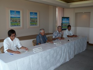 会見でヨネックスシニア沖縄の実施要項を説明する野津実行委員長（左から３人目）ら関係者＝13日、エメラルドコーストゴルフリンクス