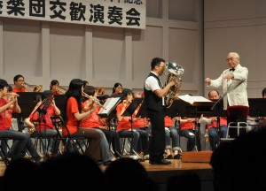 佐藤菊夫さん（右）が指揮を取り質の高い演奏を披露した。中央はソリスト・ユーフォニアム奏者の齋藤充さん＝３日、マティダ市民劇場