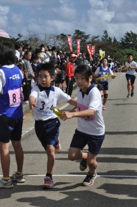 「まかせたよ。頑張って」。次の走者にたすきを手渡す児童＝26日、上野体育館周辺コース