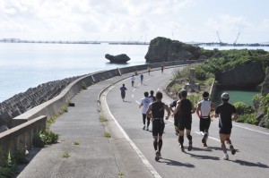 建設中の伊良部大橋を遠目に見ながら走る選手たち