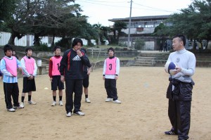 生徒たちにパス回しなどラグビーの基本プレーを指導する大西さん（右）と相沢さん＝15日、平良中グラウンド