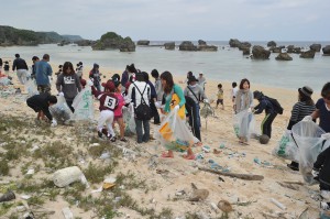 「当たりごみ」を楽しみに砂浜を清掃する参加者たち＝５日、保良漁港隣の砂浜