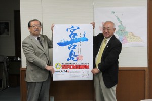 第27回全日本トライアスロン宮古島大会の公式ポスターを発表する下地市長（右）と長濱政治副市長＝４日、市長室