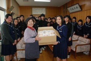 津嘉山さん（左）から級長の恩川さんに合格祈願まんじゅうが手渡された＝４日、下地中学校