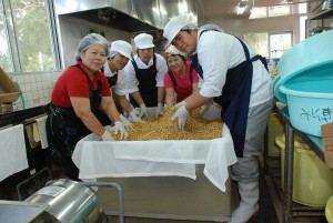 講師の指導を受けながら大豆と麦こうじを混ぜる生徒たち＝９日、ＪＡの特産物加工施設