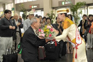 ツアーの代表にミス・ティダから歓迎の花束が贈られた＝８日、宮古空港