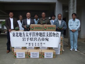 支援物資のカボチャを前に諸見里会長（前列右から３人目）ほか関係者ら＝５日、多良間村役場