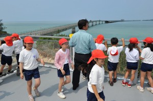 ステーションの屋上から伊良部大橋を見学する久松小の児童ら＝14日、平良字久貝の見学ステーション