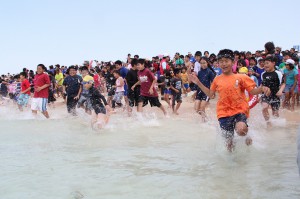初泳ぎで海に駆け込む子どもたち＝３日、与那覇前浜ビーチ