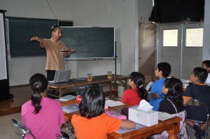 児童にサンゴの生態などを説明する梶原さん＝16日、狩俣小学校