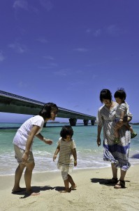 海辺で宮古の夏を満喫する親子連れ＝９日、池間大橋橋詰め