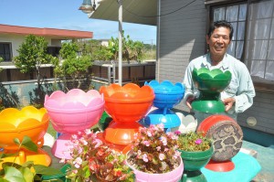 漂着した漁具の浮玉で植木鉢を作っている川満さん＝15日、城辺砂川の川満さんの自宅