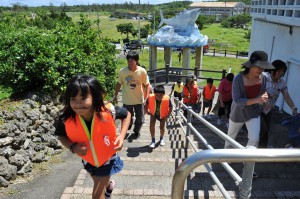 救命胴衣を着て高台に向かい足早に移動する児童生徒ら＝12日、池間島
