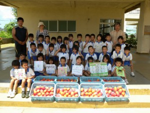 マンゴーのプレゼントを喜ぶ子どもたち＝14日、上野小学校