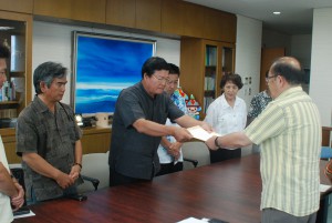大浦会長（左）が長濱副市長に要請書を手渡した＝５日、市役所平良庁舎