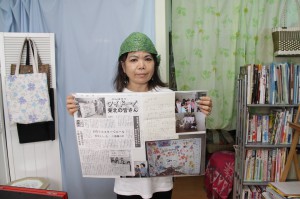 届けられたポスターが西多賀小学校に送られたことを伝える手紙と贈呈時の写真、新聞記事のコピーを手にする西里さん＝12日、アートスペース　アキュリア