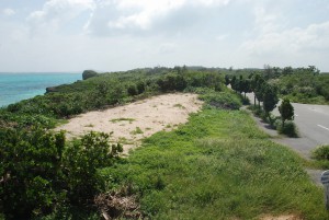 砂地から道路（右）に向かって鉄筋コンクリート建てのバイオトイレと駐車場が整備される＝17日、池間島のフナクスビーチ付近