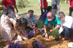 記念植樹を行う石原さん（右）と関係者ら＝15日、市熱帯植物園