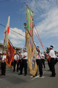 自治会旗や五穀豊穣旗を立てて集落内の道路を練り歩く平良西原のミャークヅツ＝７日