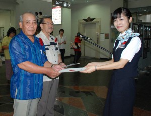 与儀さん（右）から川満支会長と長濱副市長にメッセージが手渡された＝１日、宮古空港