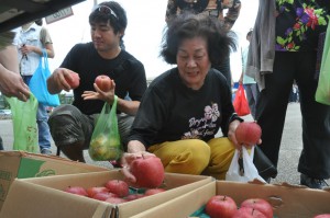 福島県のリンゴを手に笑顔の女性。ここでしか買えない甘いリンゴをゲット