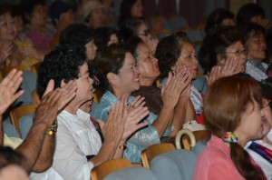 クイチャーパラダイスの公演で宮古民謡の曲に合わせて手拍子する人たち＝マティダ市民劇場