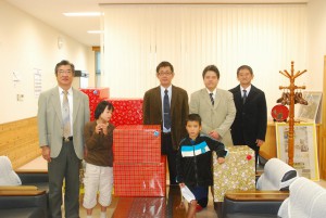 伊良部マネジャー（右から２人目）と安里マネジャー（同３人目）が伊波校長に菓子を寄贈した＝16日、宮古特別支援学校