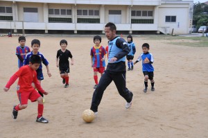 子どもたちとプレーを楽しむ藤本選手⑦＝11日、平良第一小学校グラウンド