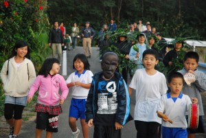 子供パーントゥを先頭に集落内をはらい清めた参加者ら＝17日、上野地区野原集落