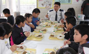 会話とともに給食を楽しむ招待客と児童たち＝24日、下地小学校食堂