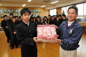合格祈願のクッキーを手渡す國仲代表（右）＝26日、久松中学校
