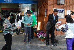 振り込め詐欺防止のチラシを配布する参加者ら＝15日、琉球銀行宮古支店前