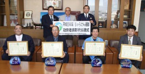 表彰を受けた（前列左から）根間さん、山内代表、松川さん、仲里代表＝14日、市役所平良庁舎