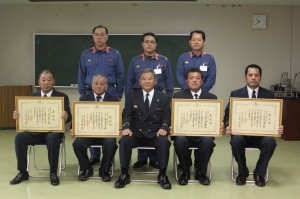 表彰された前列左から本村さん、兼島さん、譜久島さん、狩俣さん。前列中央は表彰伝達した砂川消防長＝14日、市消防本部