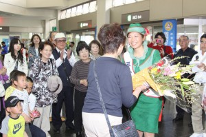 ミスサンゴの遠藤はるかさんが花束を贈呈しツアー客を歓迎した＝６日、宮古空港