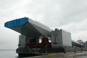 台船に積んで曳航して平良港まで運ばれた巨大な鋼製箱桁＝１９日、平良港下崎埠頭