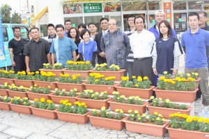 創立記念日にマリーゴールドの花が咲いたプランターを設置した商工会議所の皆さん＝５日、宮古島市公設市場