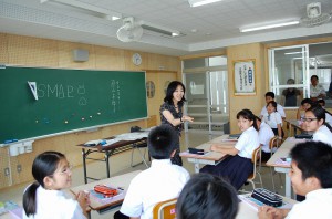 直山さん（写真中央）は、楽しくリズミカルに生徒らに質問を投げかけた＝８日、平良中学校