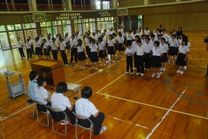 沖縄の愛唱歌「てぃんさぐぬ花」を合唱する生徒たち＝１５日、伊良部中学校の体育館