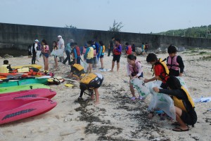 漂着ゴミを回収する参加者ら＝１２日、平良の高野漁港海岸