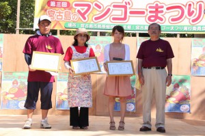 マンゴーレシピコンテストで長濱副市長（右）から表彰を受けた最優秀賞の下里由紀さん（右から2人目）と優秀賞のみゃーくの味加工推進協議会（左から2人目）とモトムラ和洋菓子店の関係者