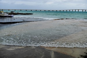 台風３号の影響で海面が駐車場近くまで上昇した＝６月４日午後７時３０分すぎ、下地の前浜港